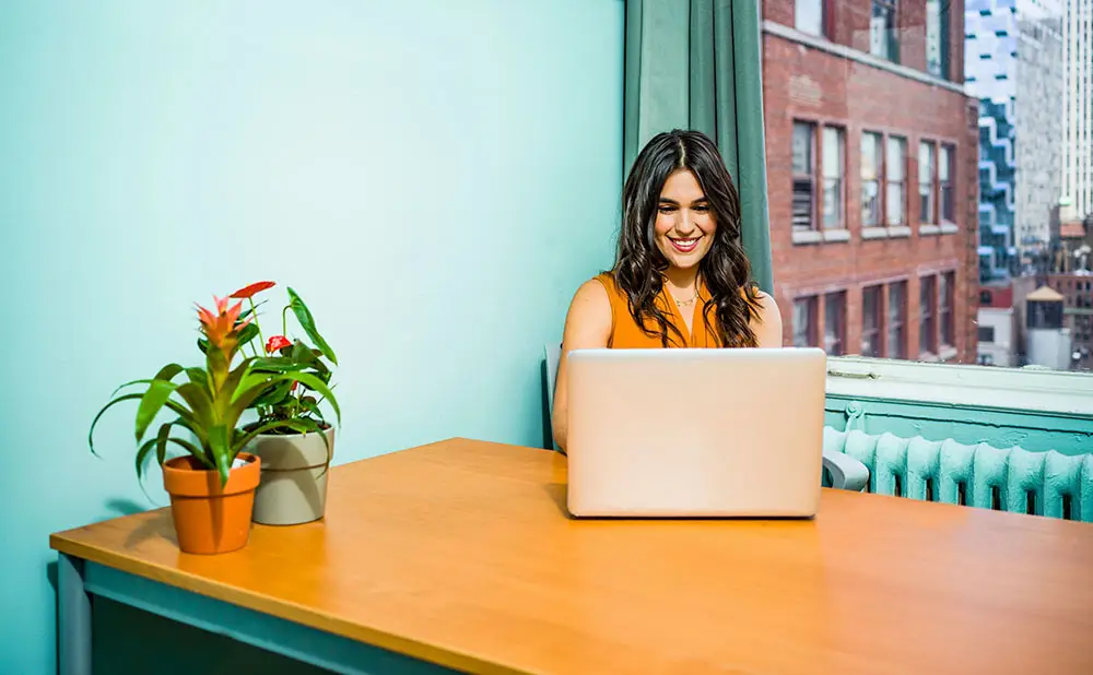happy lady doing seo services in leicester on laptop